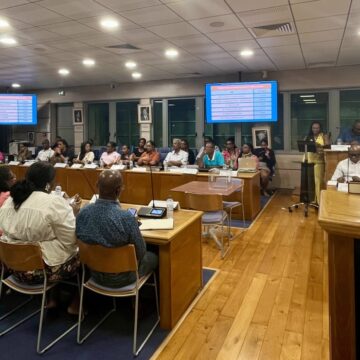 À la mairie du Gosier, le 27 avril 2026, les conseillers communautaires de la communauté d’agglomération la Riviera du levant sont installés à leurs places autour de la table ovale, micros et boîtiers de vote électroniques devant eux. Photo : Le Courrier de Guadeloupe À la mairie du Gosier, le 27 avril 2026, les conseillers communautaires de la communauté d’agglomération la Riviera du levant sont installés à leurs places autour de la table ovale, micros et boîtiers de vote électroniques devant eux. Photo : Le Courrier de Guadeloupe