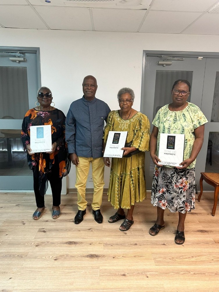 Après plus de quarante ans de blocage foncier à Sainte Anne, le maire Francs BAPTISTE a officiellement remis leurs titres de propriété à trois premières familles occupantes de la zone de Dupré, avec l'appui de Terres Caraïbes. Photo : Ville de Sainte-Anne