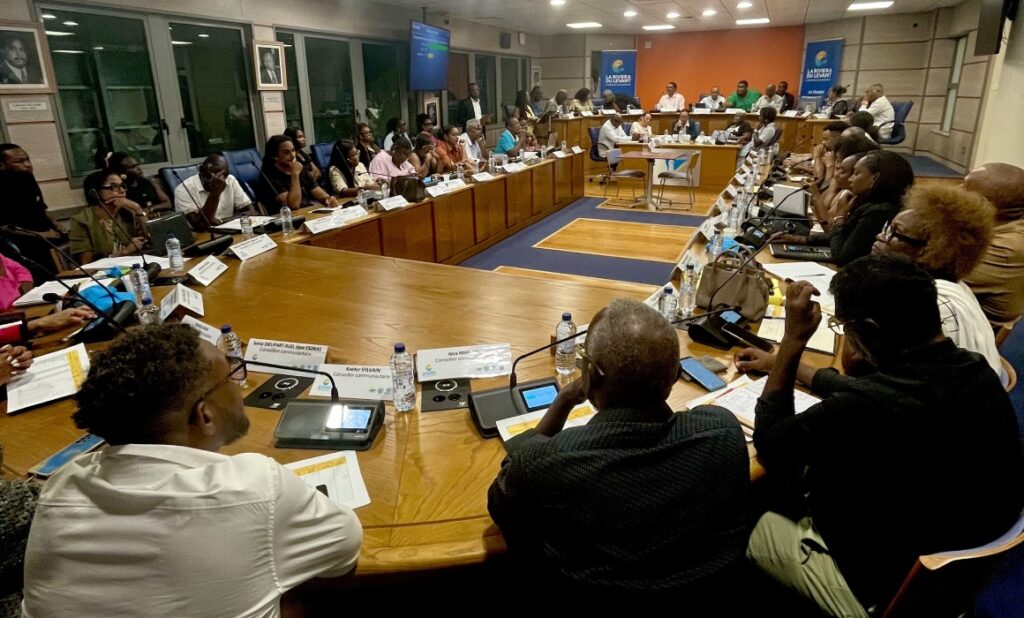 À la mairie du Gosier, le 27 avril 2026, les conseillers communautaires de la communauté d’agglomération la Riviera du levant sont installés à leurs places autour de la table ovale, micros et boîtiers de vote électroniques devant eux. Photo : Le Courrier de Guadeloupe