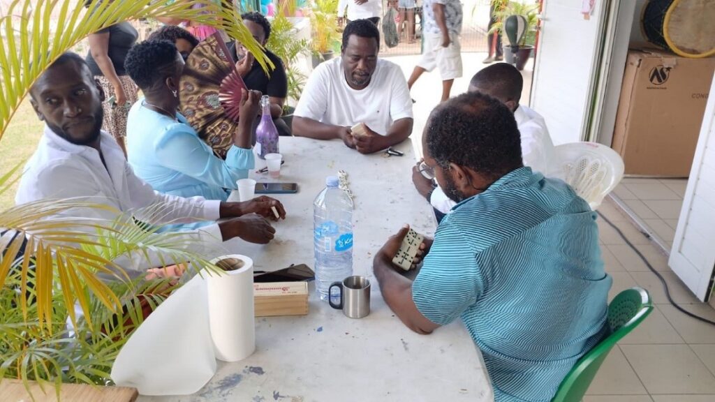 Dominos en main pour le maire Michel Mado (t-shirt blanc) à la fête des voisins de Terrain Agathon Baie-Mahault, 8 mai 2026. Photo : Ville de Baie-Mahault.