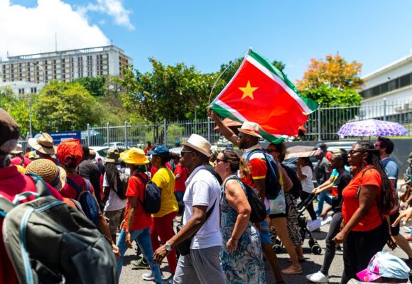 Des manifestants, brandissent le drapeau régional guadeloupéen, lors d'un défilé du 1er Mai (Fête du Travail), le 1er mai 2023. Photo : Lara Balais / AFP